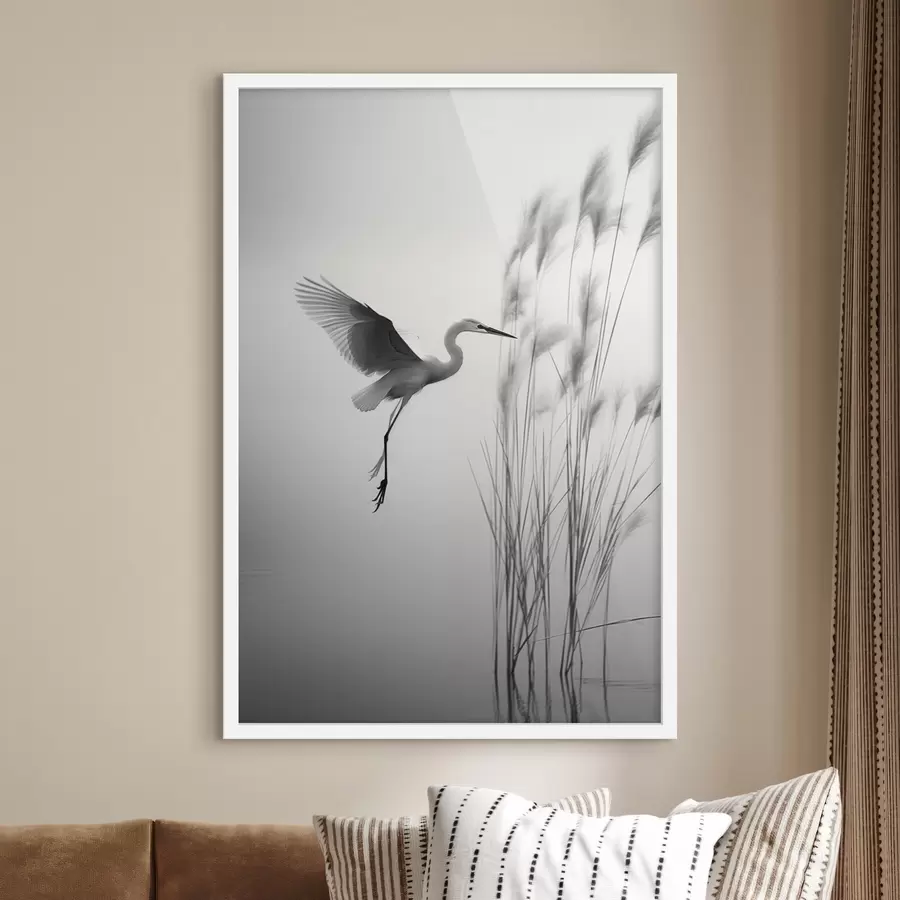 Fotobehang Een witte reiger met gespreide vleugels, vliegend in de buurt van hoog riet, zwart-witte minimalistische compositie f46693