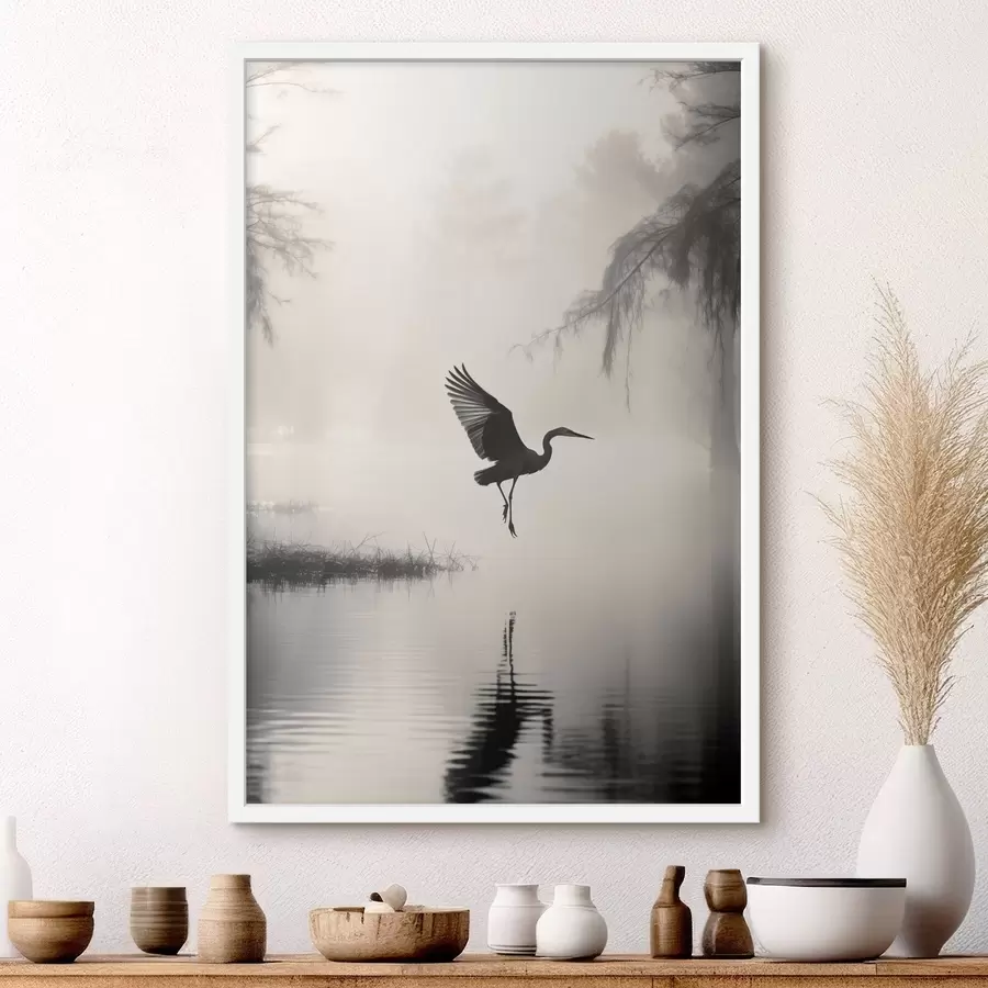 Fotobehang Een witte reiger met gespreide vleugels, vliegend in de buurt van hoog riet, zwart-witte minimalistische compositie f46694